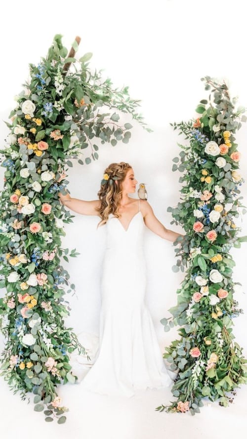 woman standing in the middle of flower backdrop