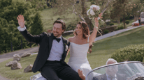 Married couple after their wedding ceremony holding a custom flower bouquet