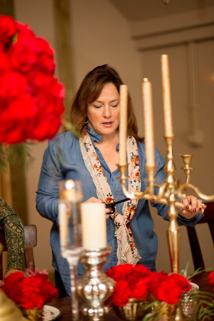 Carla, part of the J.Morris Flower teams sets up for the grand crimson=inspired table...