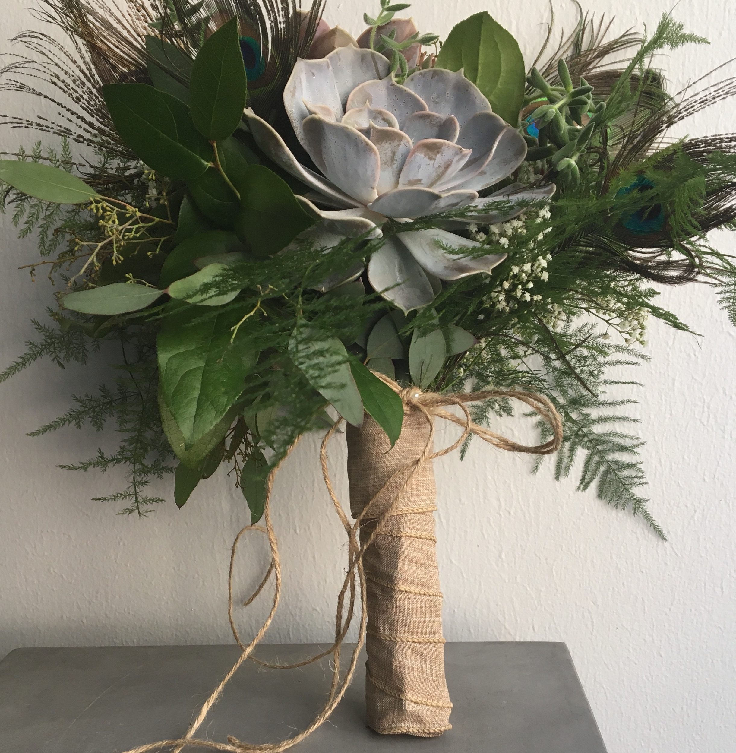 Because the Succulents and greens last out of water, we were able to use a Ballerina Wrap on the handle to hide the mechanics. This was a very popular wrap in the last decade for hand-tied bouquets.