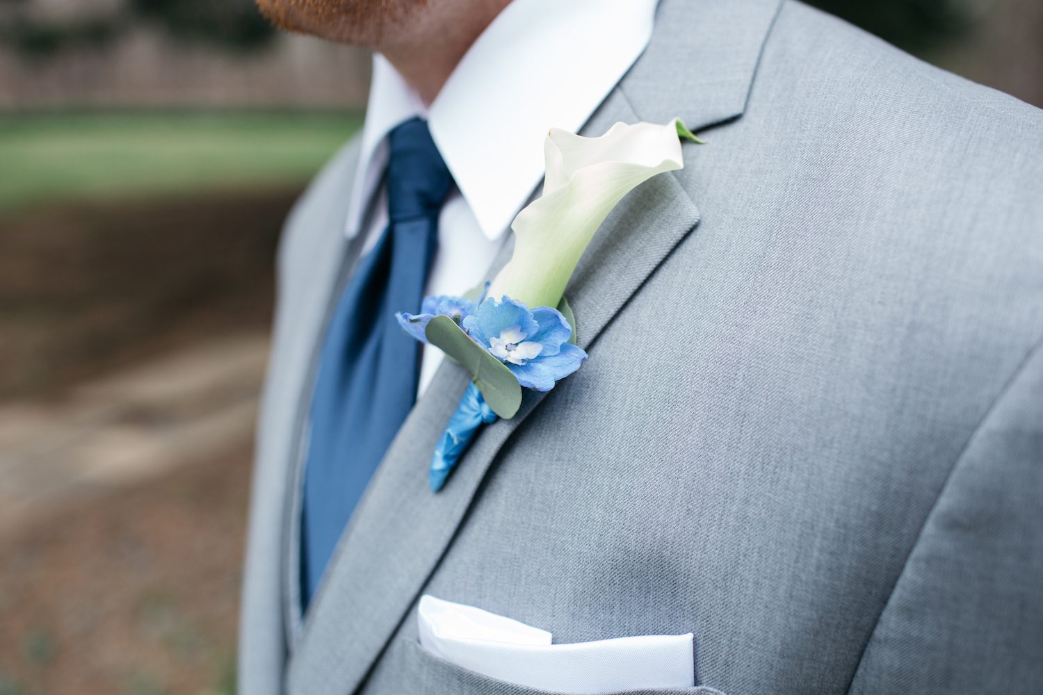 A longer thinner boutonniere with Calla Lily and Blue Delphinium. Fisher Photography.