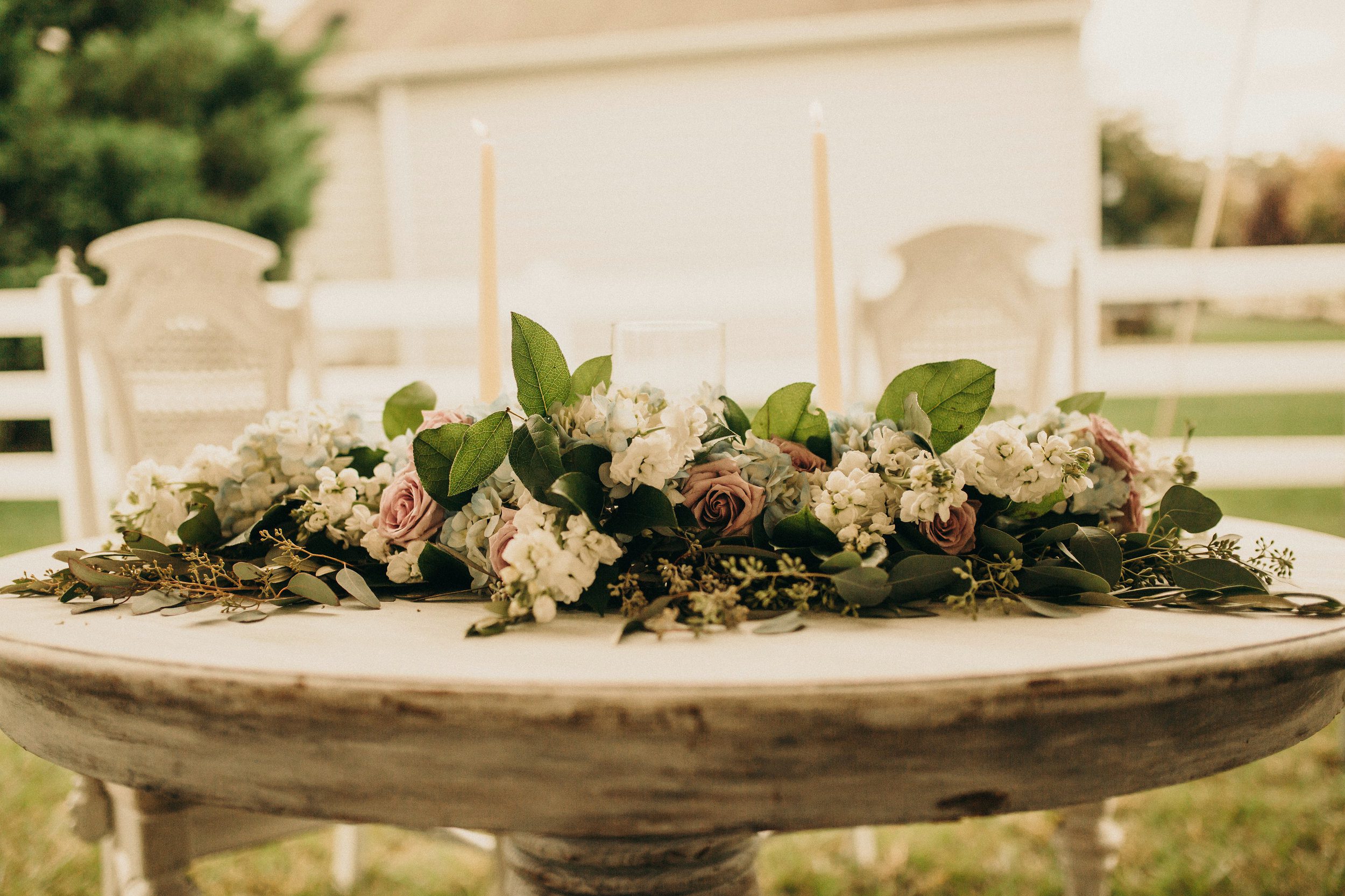 Florals and greens for a Sweetheart table with Seeded Eucalyptus, Salal, Stock, Hydrangea and Roses. Photography by Olivia Markle.