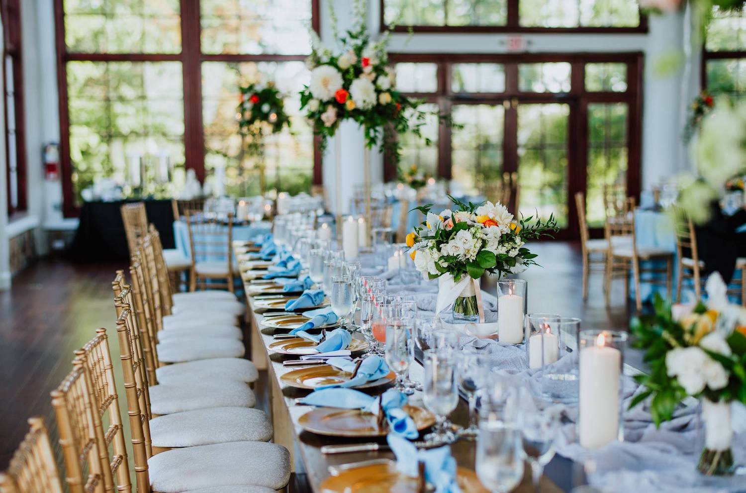 Emily Clack Photography at Raspberry Plain Manor, a King’s table with pillar candles in cylinders. bridesmaids bouquets and tall floral centerpieces on vintage gold plant stands.