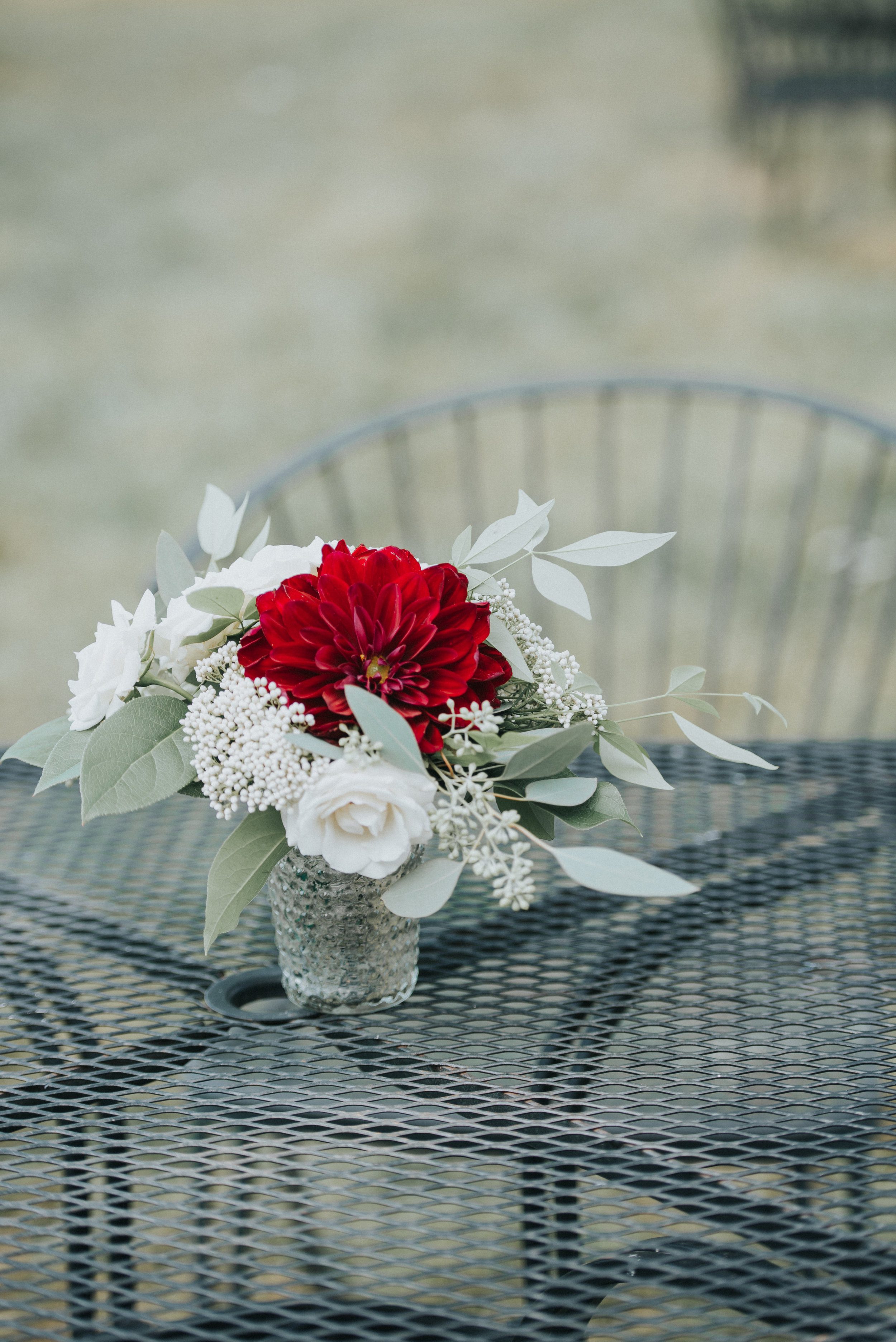 A vibrant red Dahlia on a table meant for lounging. Photography by Purple Fern.