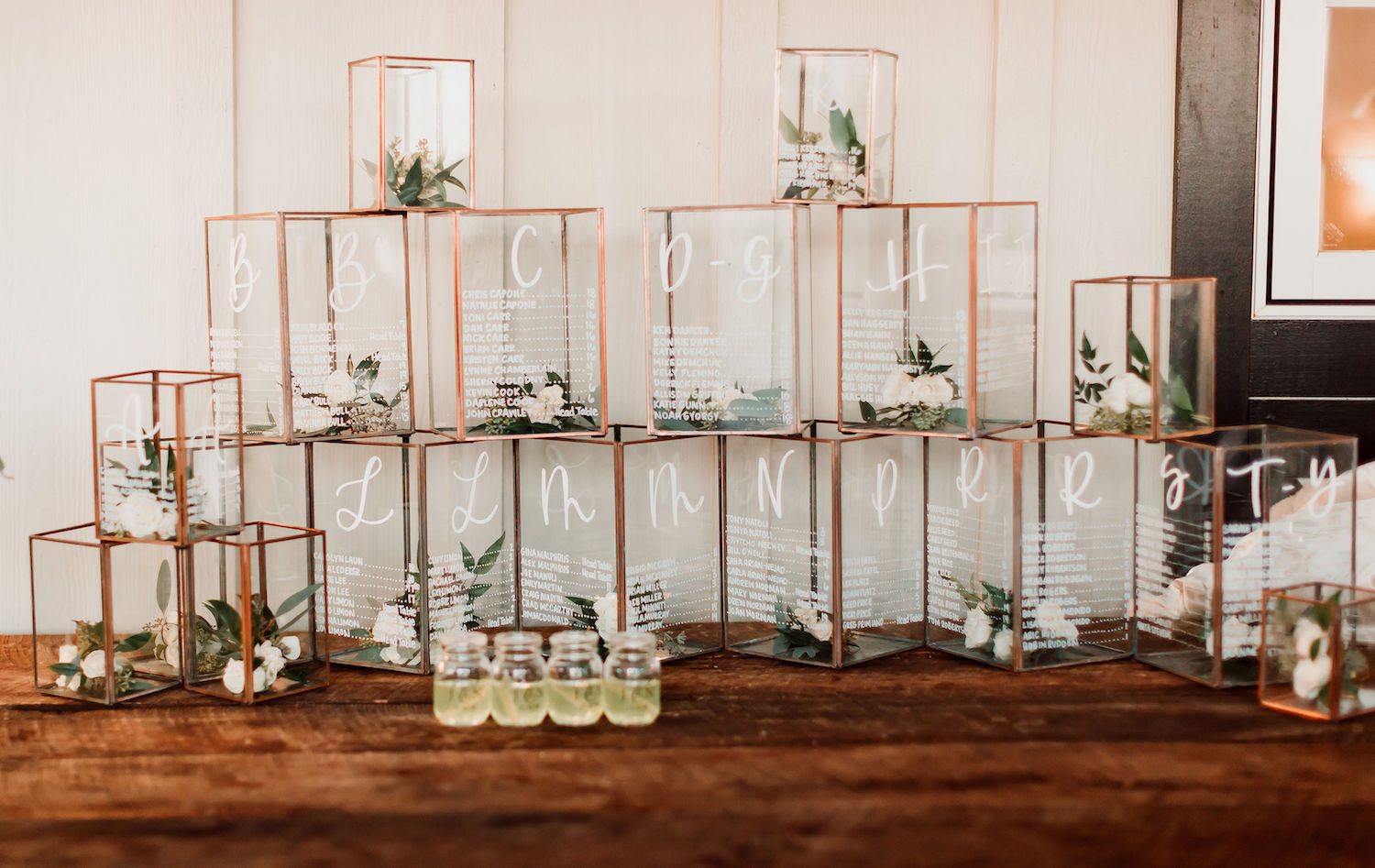 Jami, the bride, used these copper and glass lanterns with the names of their guests and table assignment etched into the glass. We added Ivory Spray Rose and a mix of greens and voila - flowers everywhere. Photography by Hay Alexandra. Table at Sha…