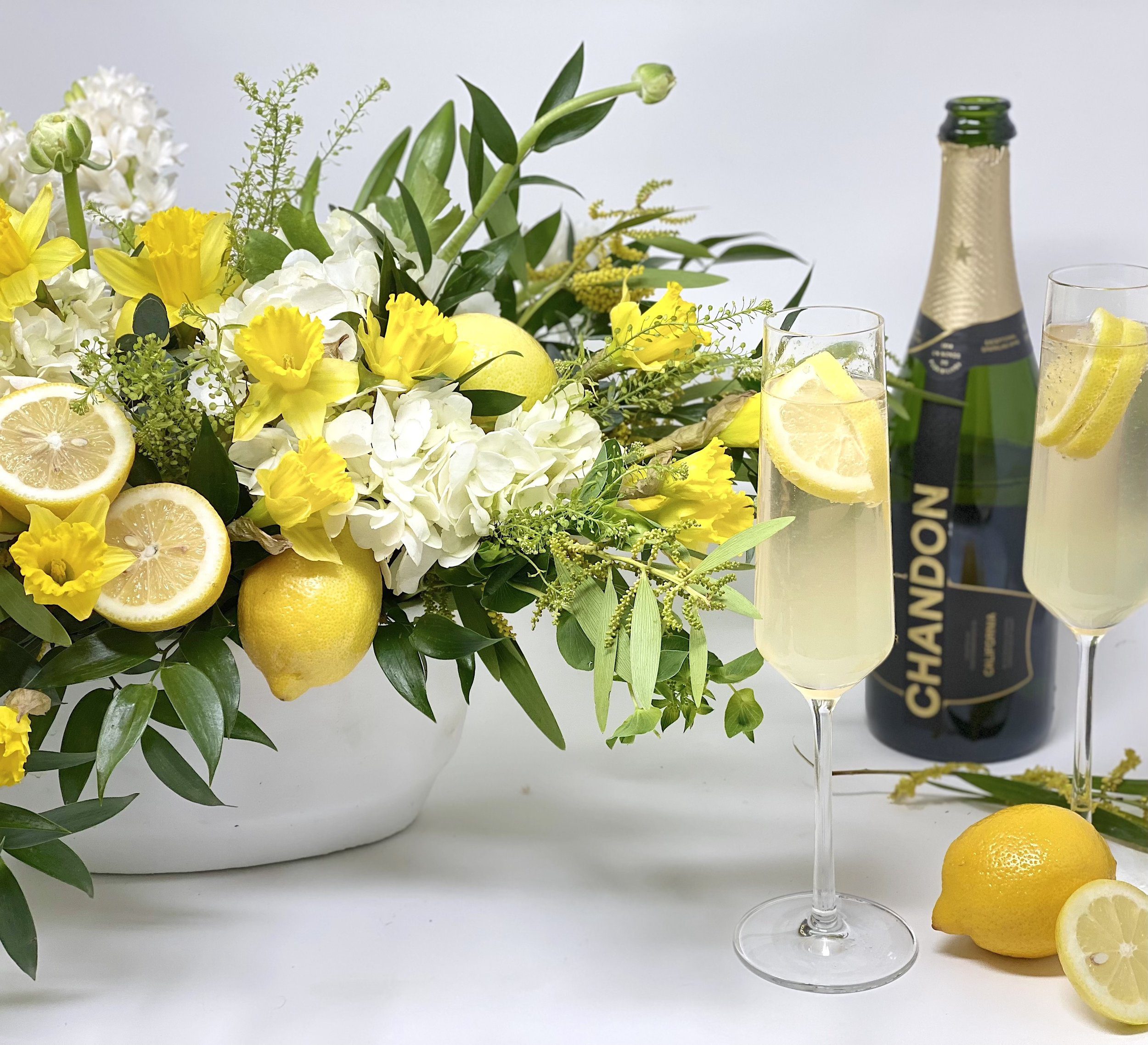 Daffodils, lemons, hydrangea and Ruscus in a white ceramic vase for spring