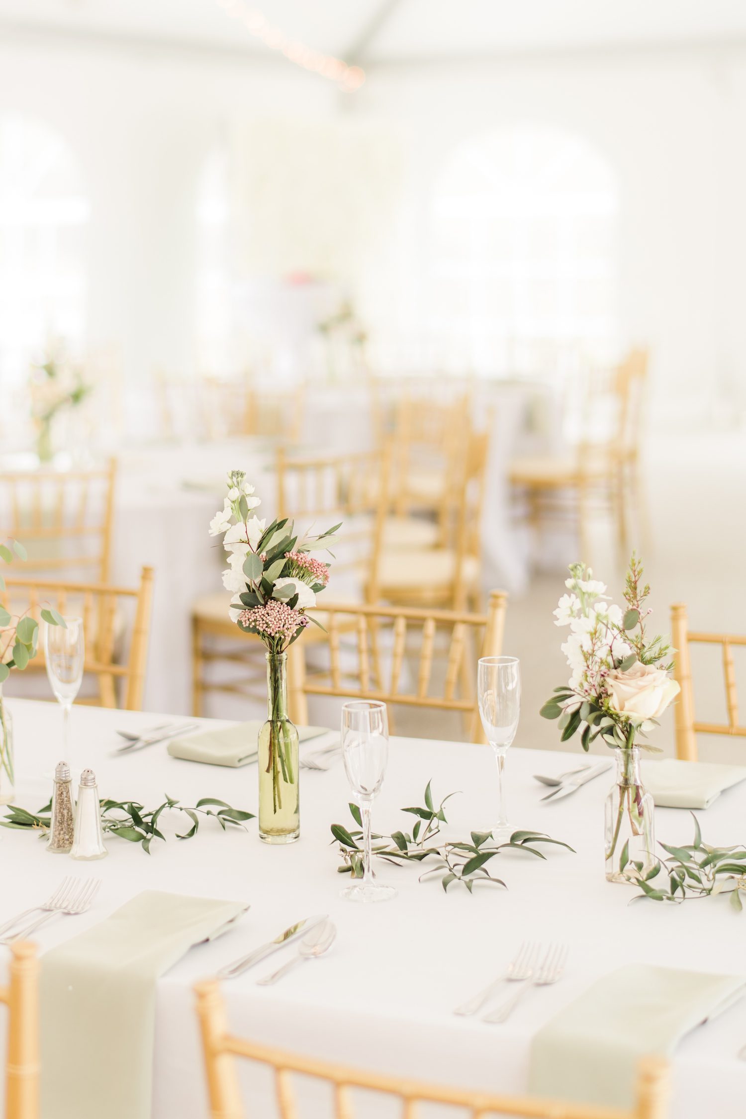 Long tables at Rust Manor House with loose greenery and bud vases. Photography by Stephanie Messick.