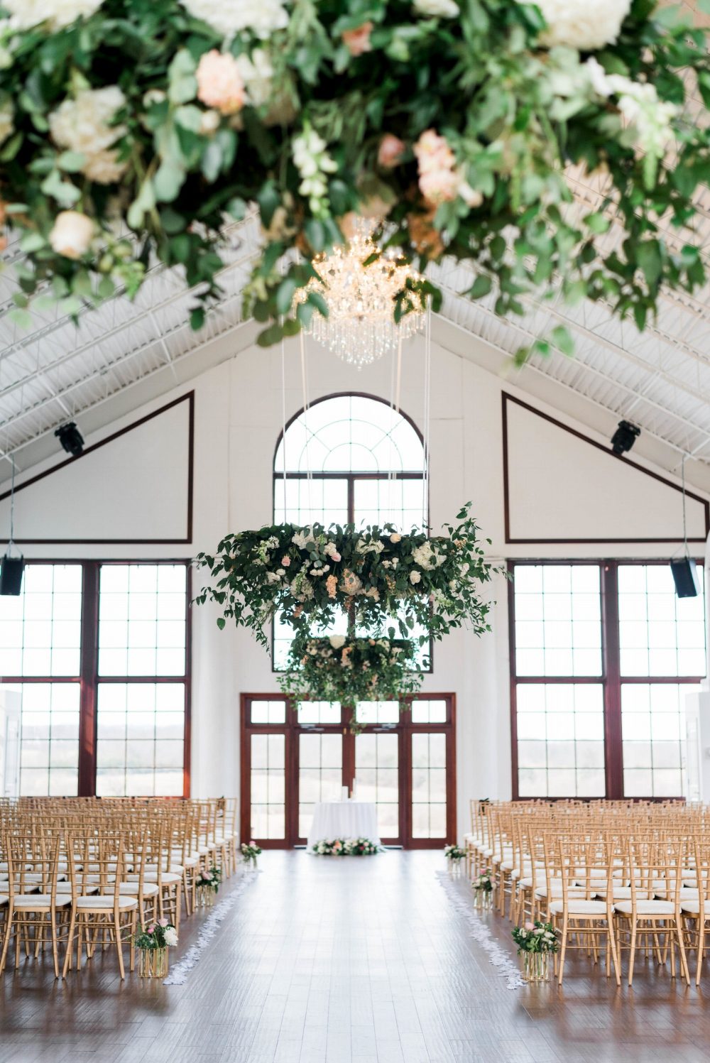 Stunning floral and greenery installations at Raspberry Plain Manor, Leesburg, Virginia in April, the beautiful chandelier at the venue is framed by our designs. The wedding party processed under the elegant installation creating a gorgeous atmosphe…