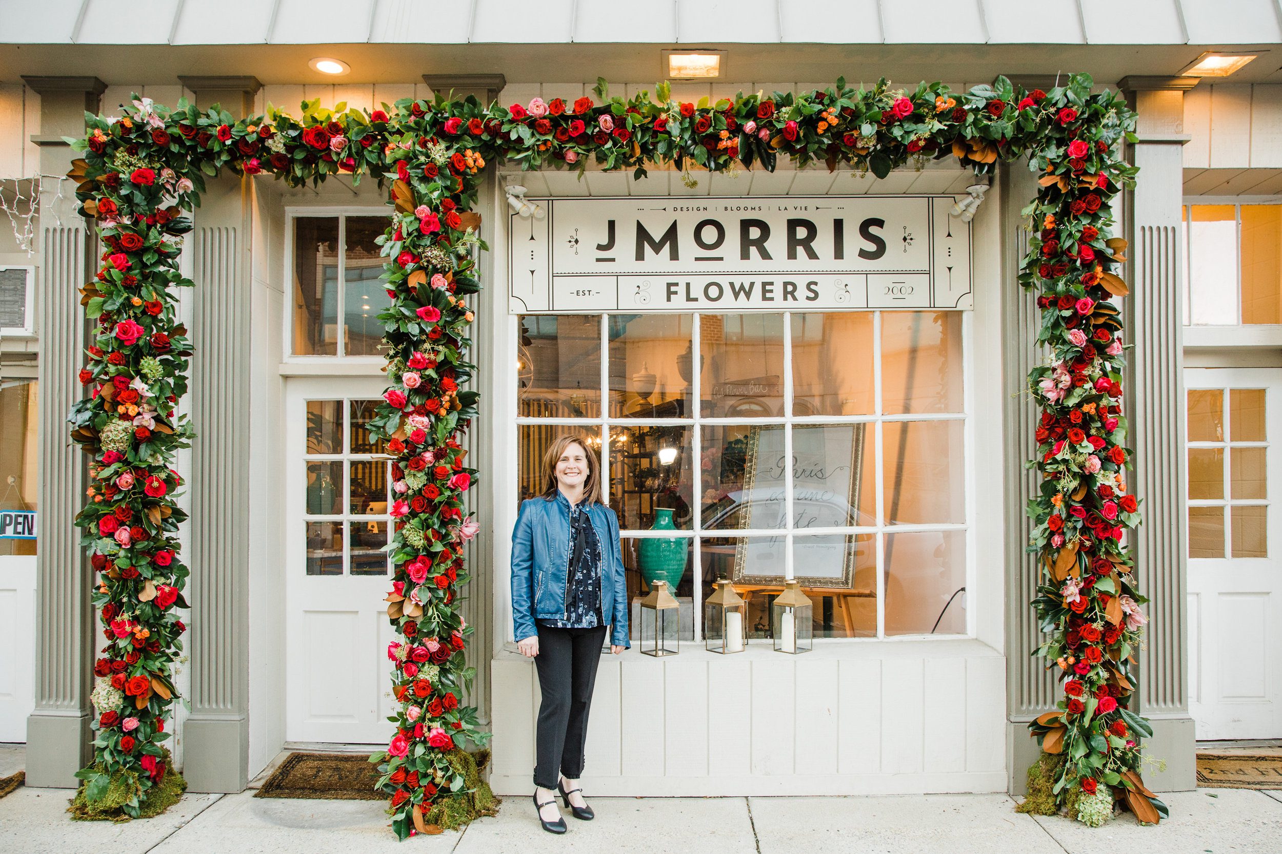 Jennifer Morris, Owner and Director of Blooms for J. Morris Flowers, 120 East Market Street. Ruby Red, Burgundy and burnt Orange strike a balance with blush pink and greens. This installation was a team effort under the direction of Jennifer, inspir…