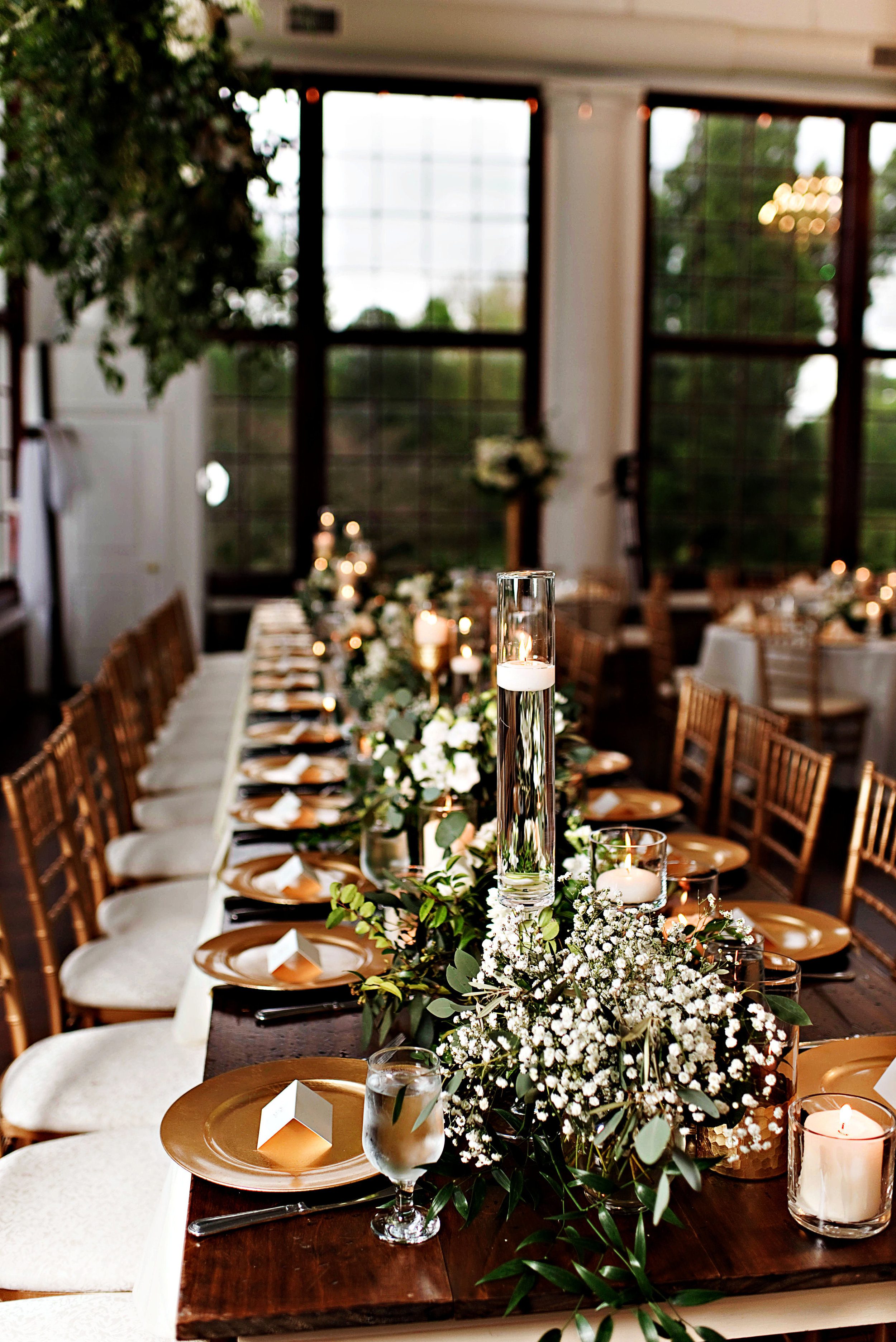Head table featured vases of flowers and greens repurposed from the ceremony structure. The Photography Smiths.