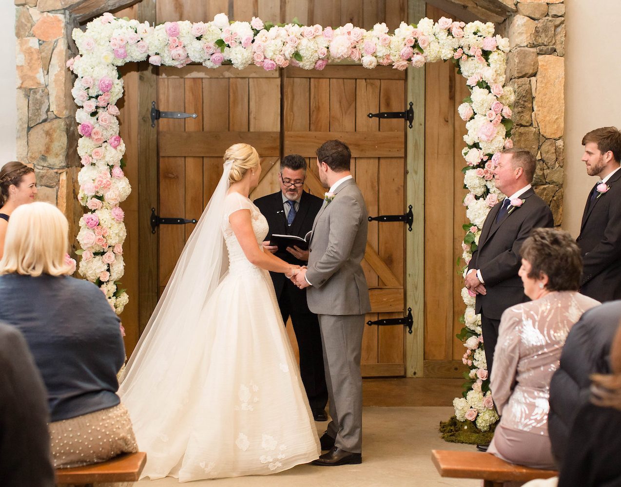 Stone Tower Wedding with full floral arch. Photography by Candice Adelle.