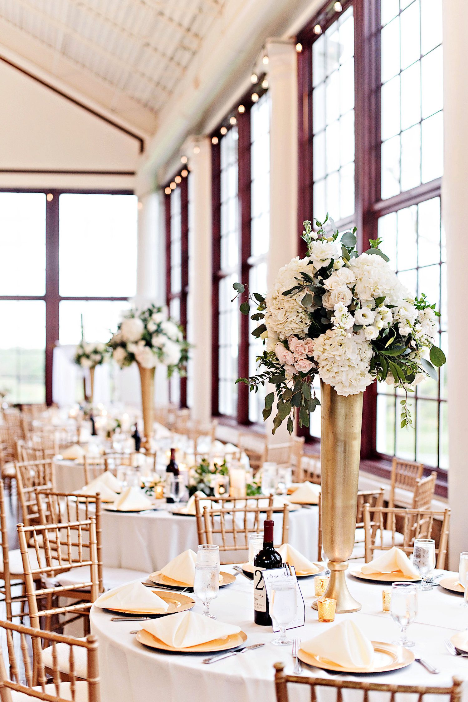 The-Photography-Smiths-Tall-Centerpieces-Gold-Pilsner-white-flowers-greenery.jpg