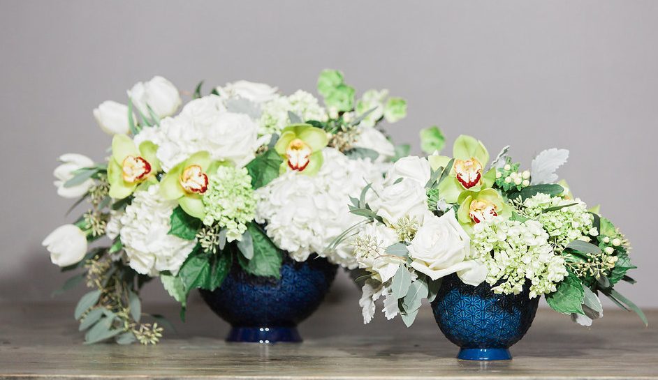 The Pierre Compote bowl in two sizes with Hydrangea, Hellebore, Roses, Green Cymbidium Orchids and Hypericum Berry. The large one is called "Crystal", the medium arrangement is "Snow."