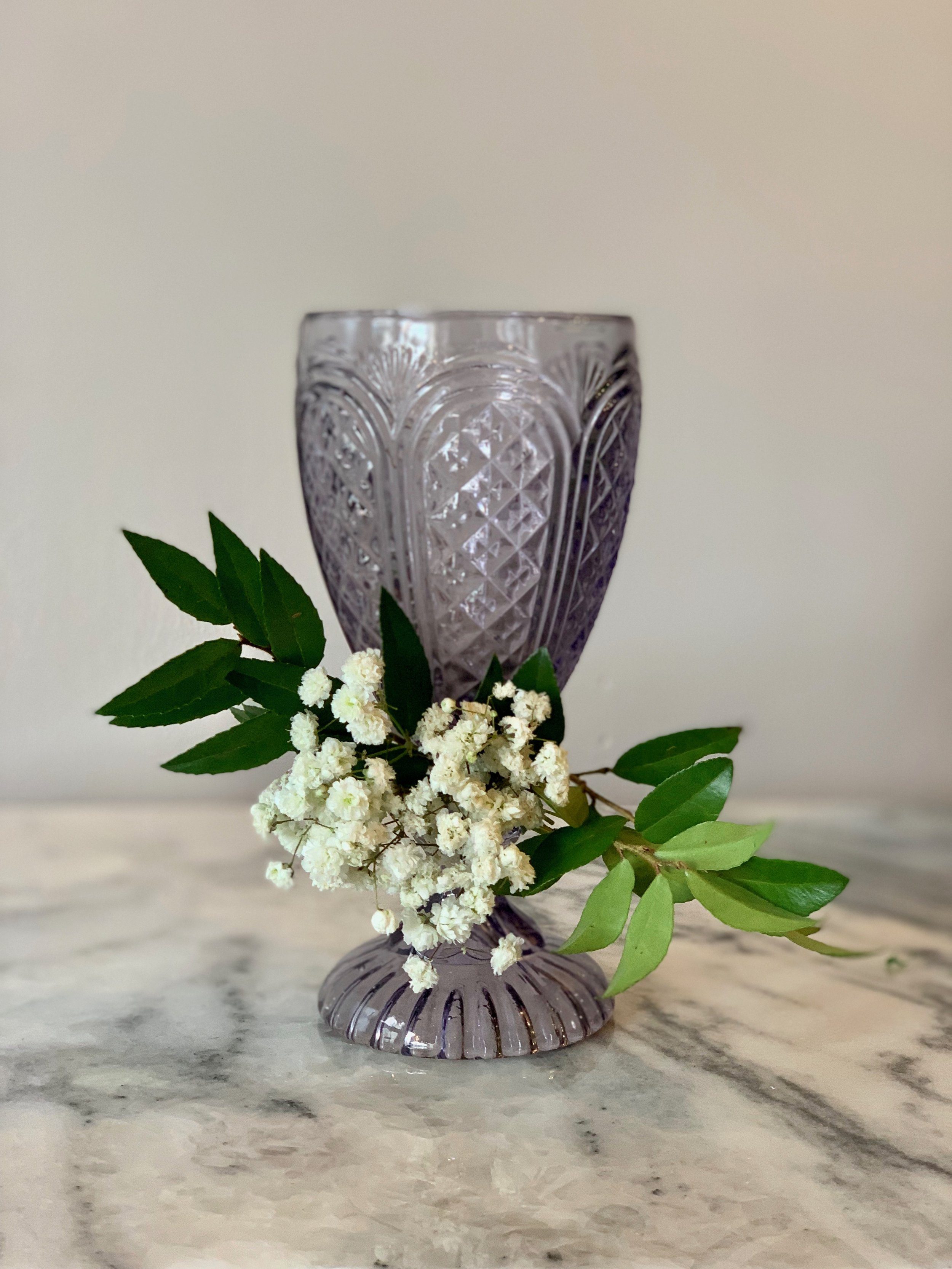 Wine glass with Babies Breath and greenery.