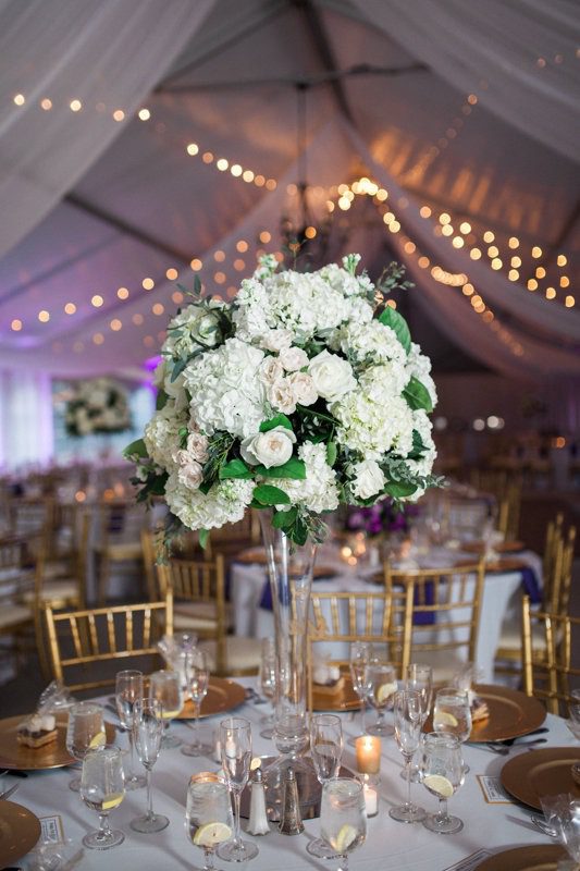 Each vase and votive must be cleared away, a service that your florist will provide. Gorgeous tall centerpiece in pilsner vase at Rust Manor House in Leesburg. Photography by Birds of a Feather.