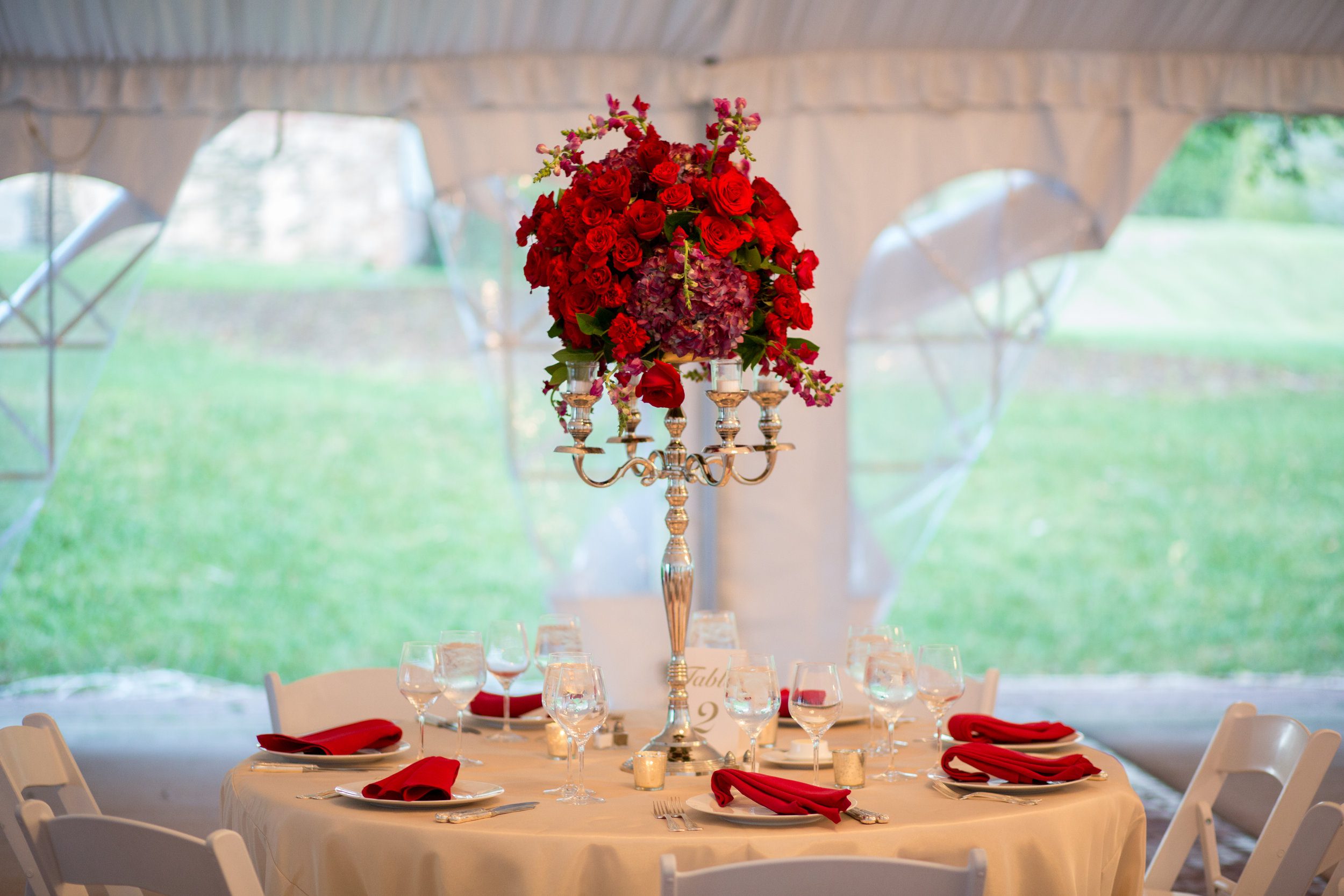 A tall centerpiece allows space below for conversation and raises the level of the decor. Oatlands Historic Gardens, Northern Virginia. Photography by Tony J.