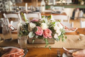 Wooden boxes, lanterns with flowers bundles and accent pieces served the long, farm tables well. Photography by Carly Romeo.