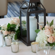 Lanterns with mounded flowers on one half of your tables