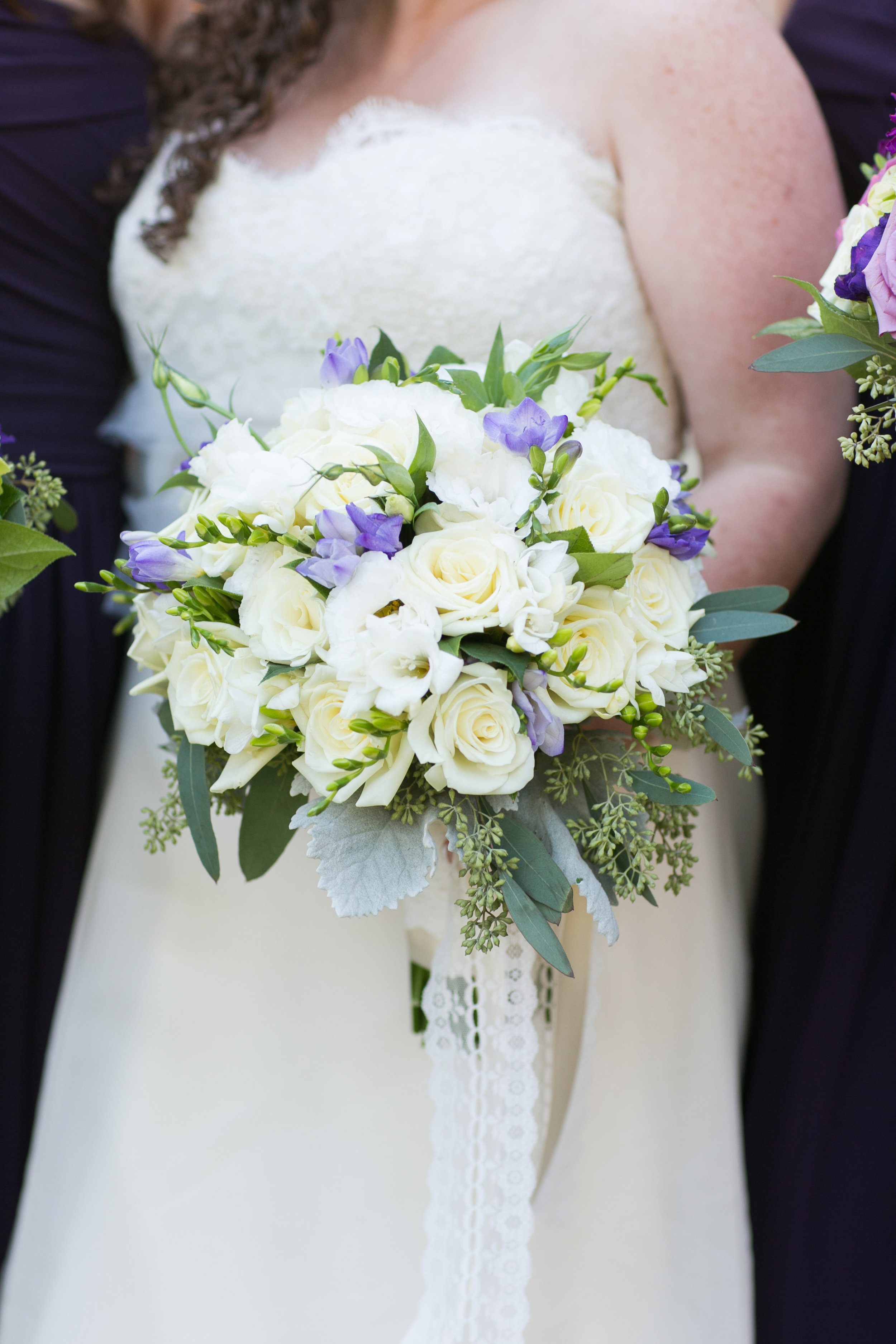 The bridal bouquet and all it's glory! Lavender Freesia, white Freesia, white roses, white Lisianthus, seeded Eucalyptus, gray Dusty Miller leaves and satin and lace ribbons.&nbsp;