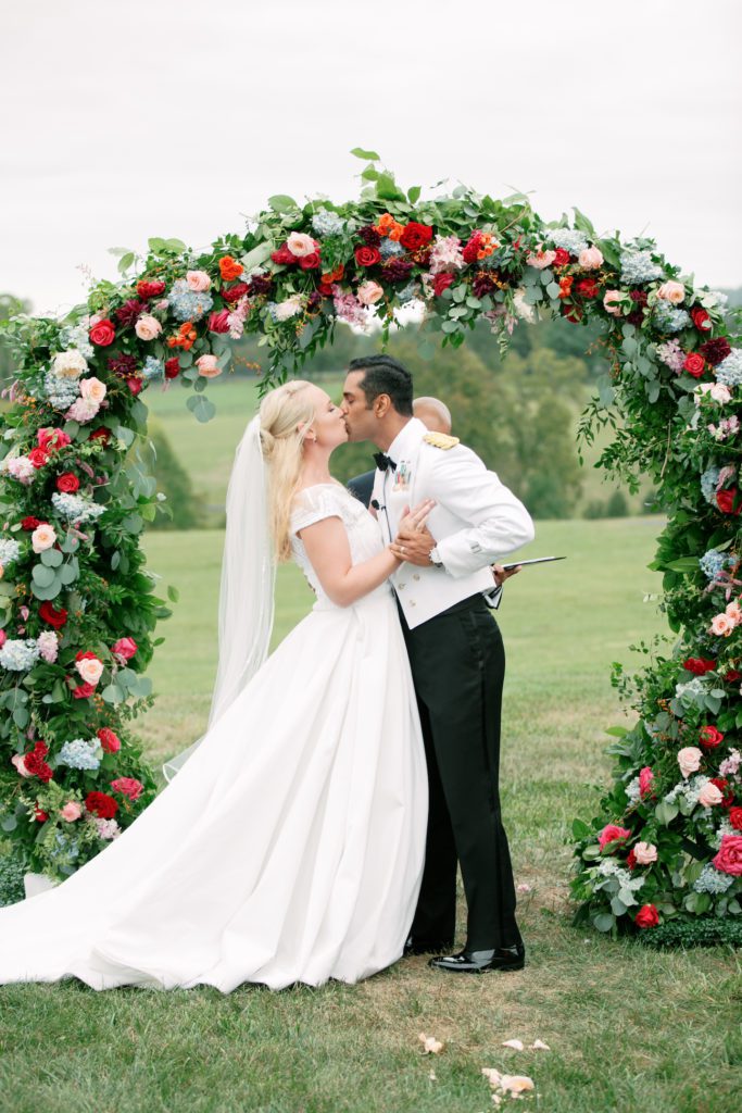 bride and groom kissing under an alter bride and groom kissing under an alter