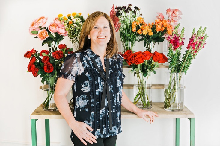 jennifer-standing-in-front-of-flowers